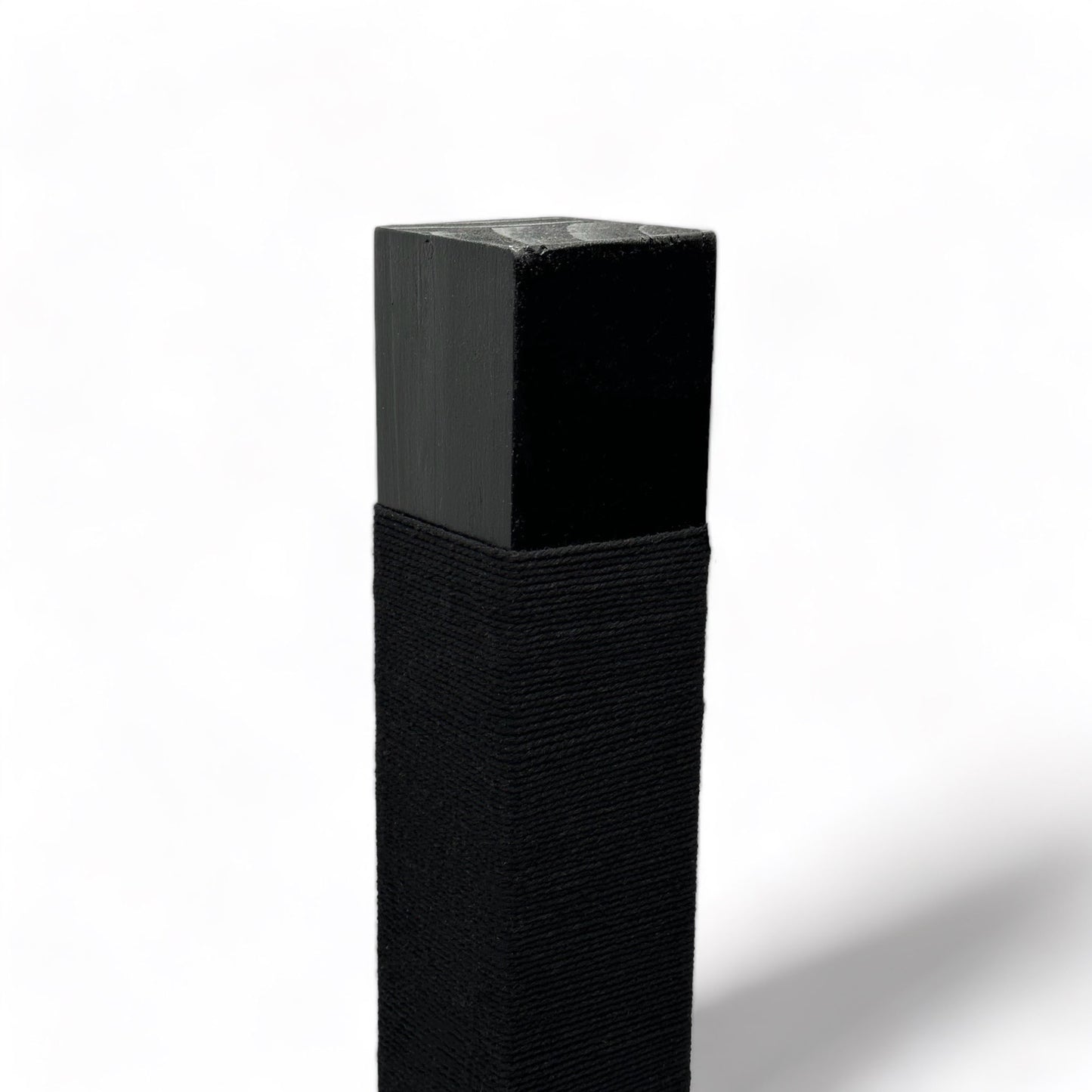 On an angle: top of black reusable solid wood cat scratching post looped in black cotton cord 