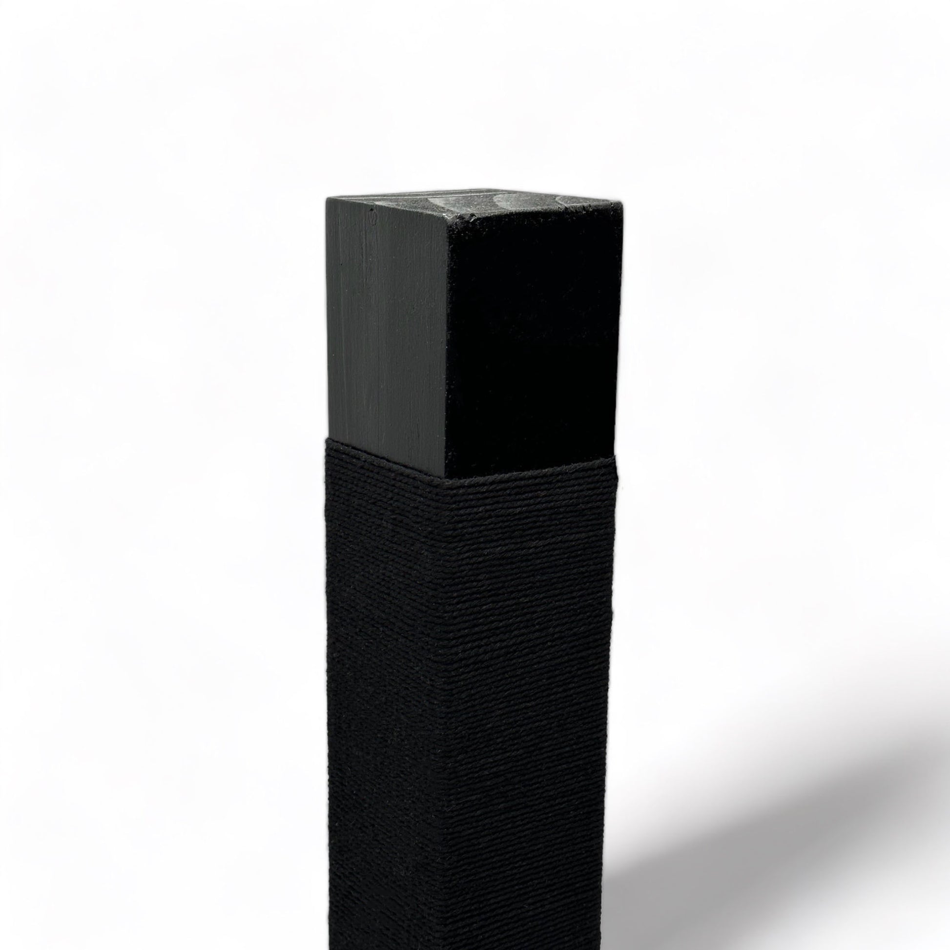 On an angle: top of black reusable solid wood cat scratching post looped in black cotton cord 